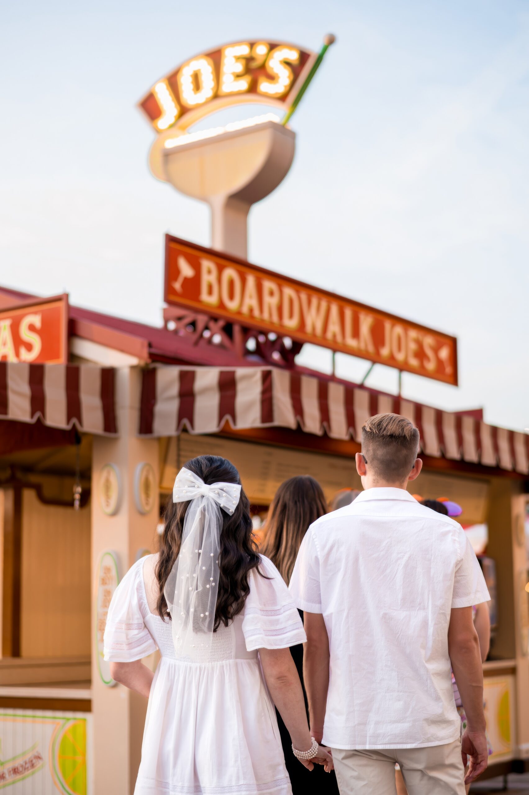 Couple holding hands candid boardwalk