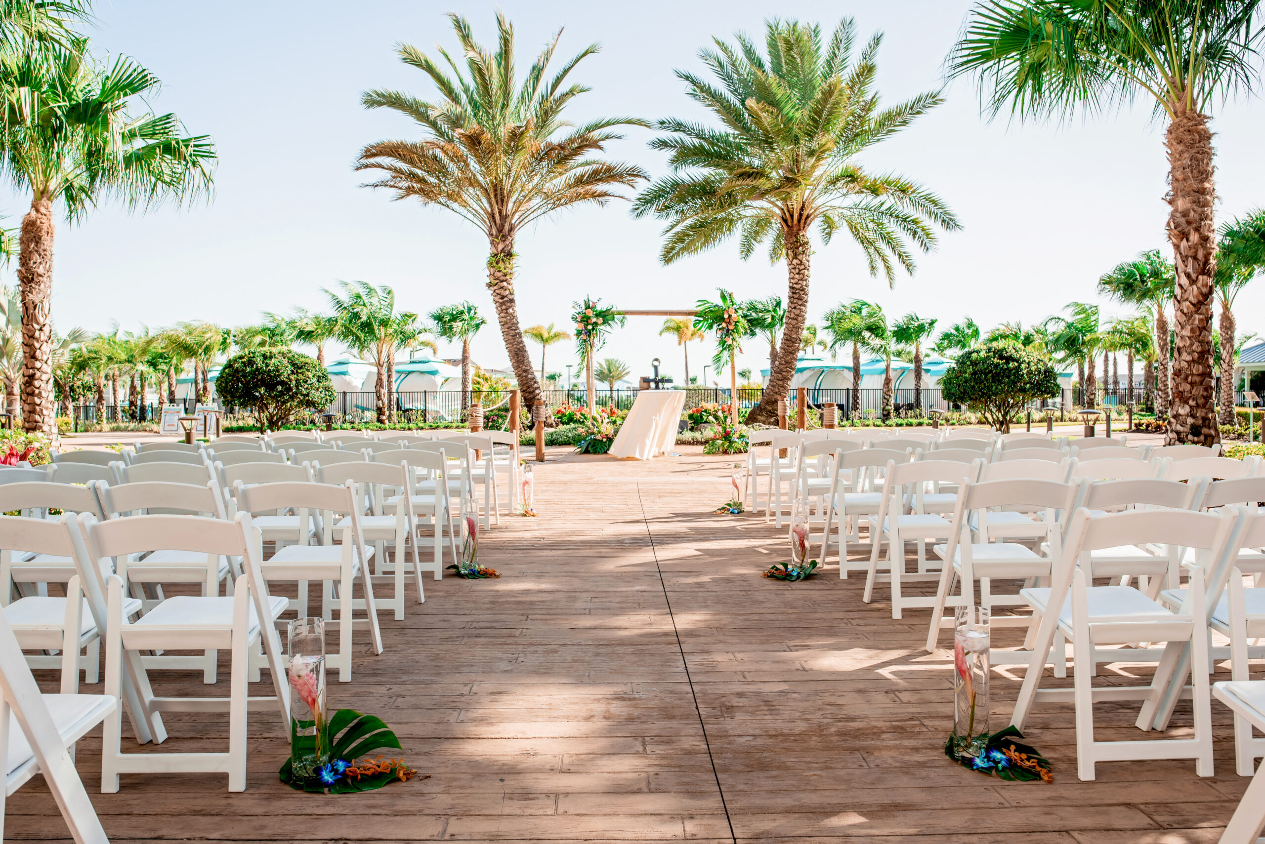 Orlando resort wedding ceremony setup with tropical floral decor and palm trees in the background


