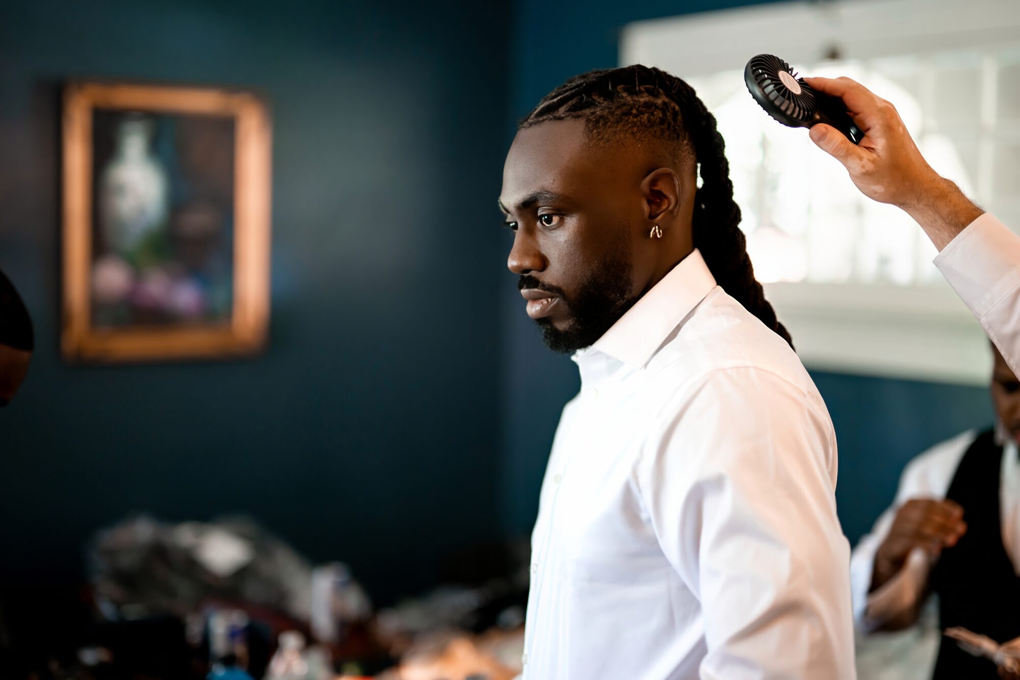 Groom has his hair styled while getting ready at Sydonie Mansion
