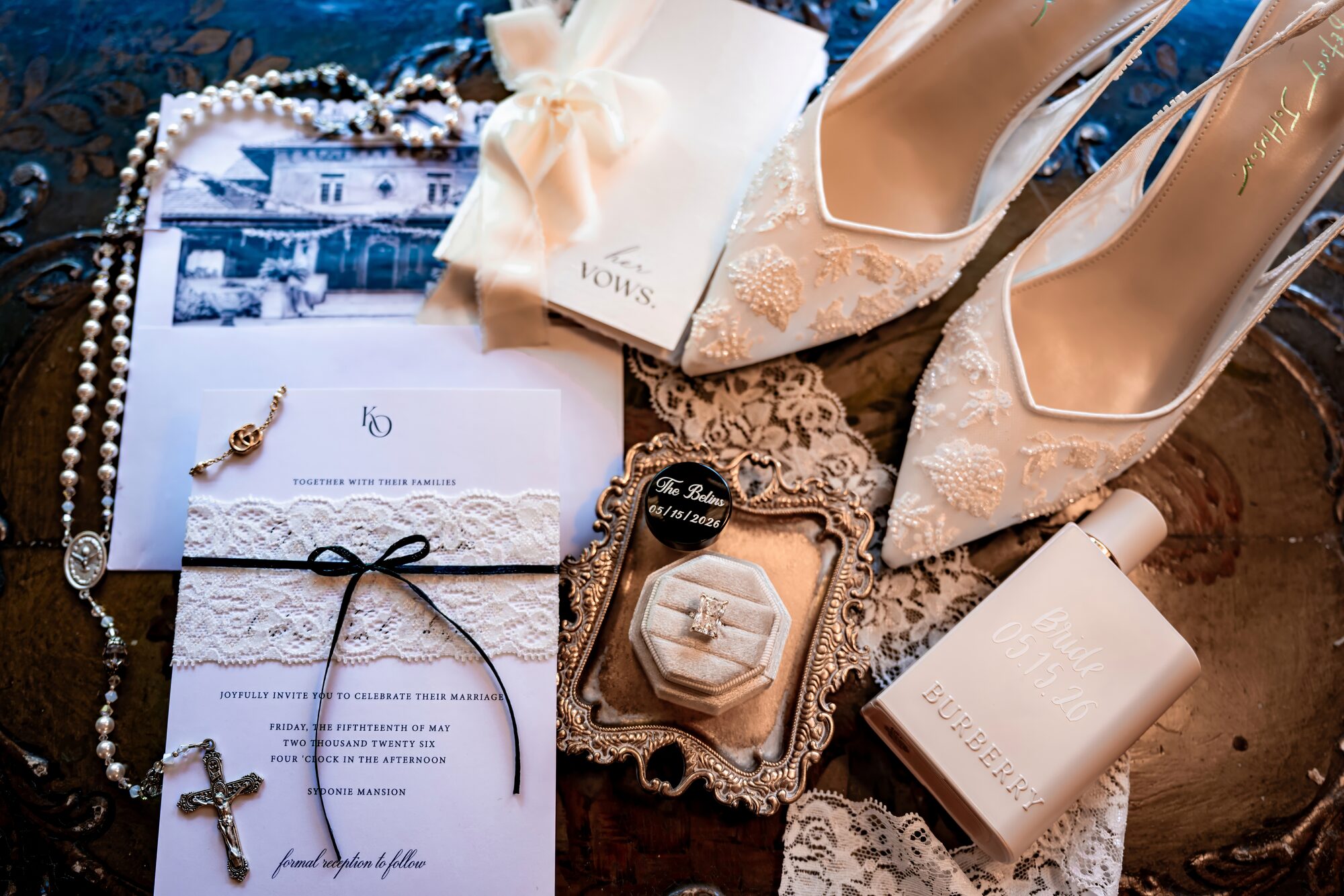 Flat lay of the bride's invitation, heels, pearls and jewelry