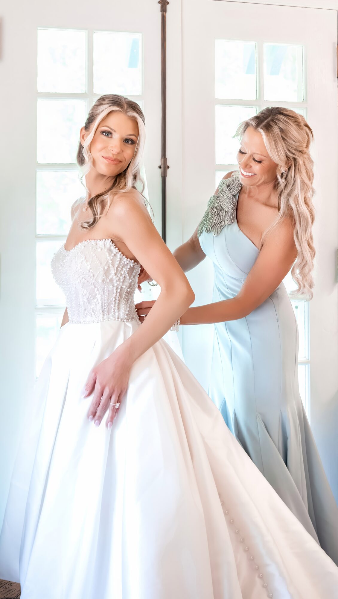 Bride shares a first look with her maid of honor in a blue dress