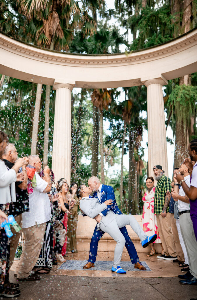 Ben and Leo share a dip and a kiss as guests toss confetti at their Kraft Azalea Garden elopement