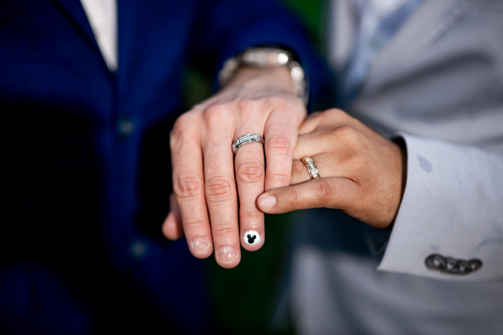 Ben and Leo show their wedding rings, one with a hand-painted Mickey Mouse nail