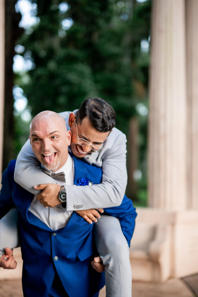 Ben and Leo laugh through a piggyback at their Kraft Azalea Garden elopement